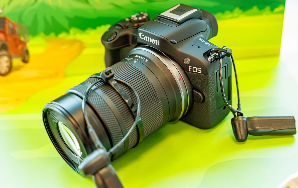Canon EOS R50 with RF-S 55–210mm lens; pictured lens is not included in the body-only recommendation.